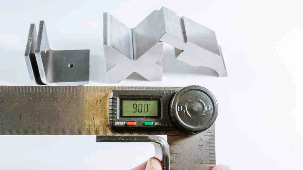 An image of a digital caliper measuring material thickness. It showcases the display reading a precise 90-degree measurement