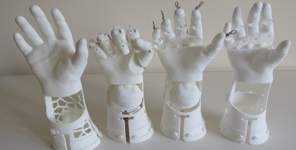 A close-up view of four nylon 3D printing prosthetic hands with different postures of fingures