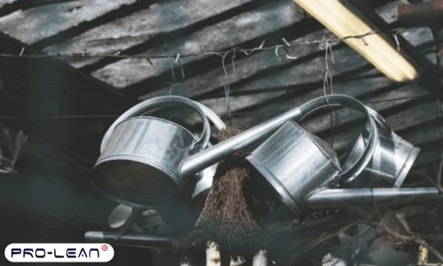 Alt text: A shot of grey galvanized steel watering can hanging from a wire