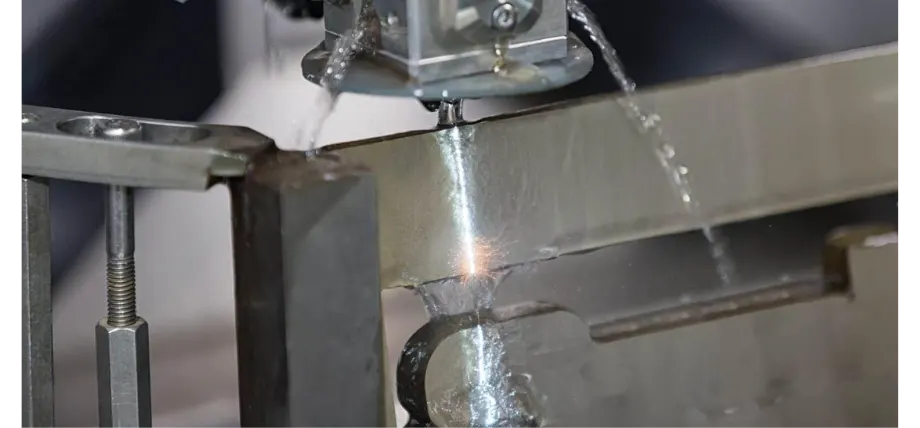 Wire EDM machine generating spark on a metal piece