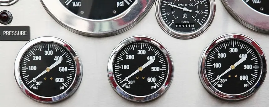 A section of a classic car dashboard showing stainless steel trims