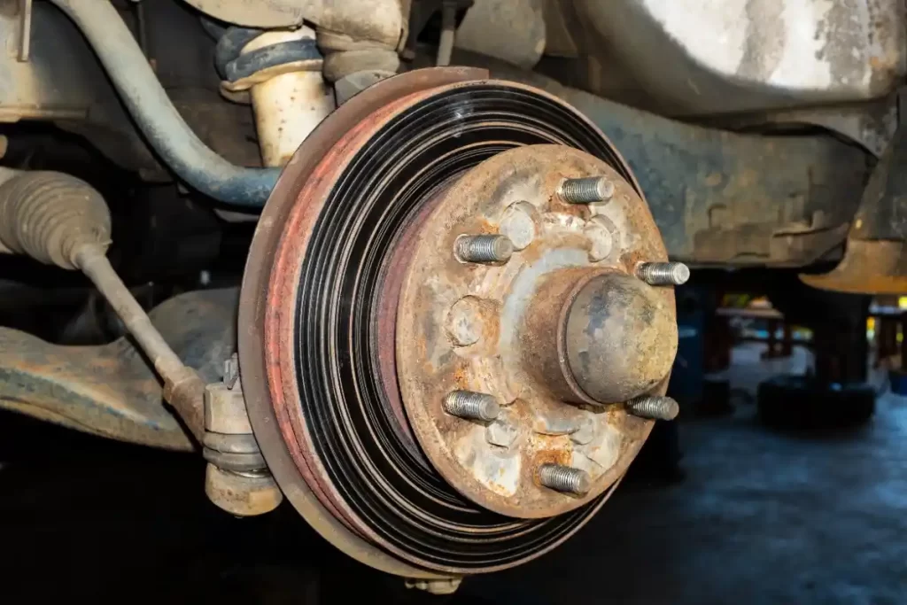 A car wheel hub with an old brake drum and exposed lug studs