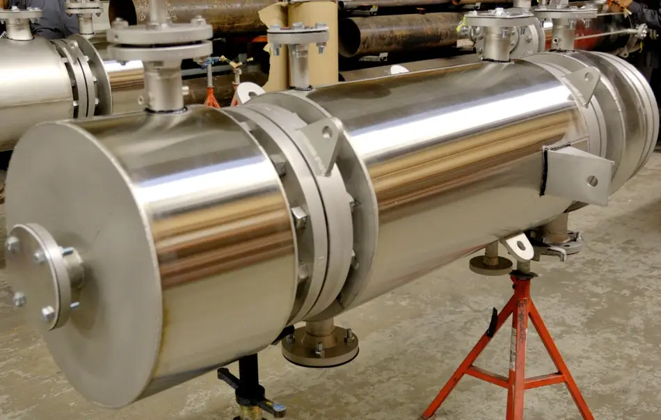 A cylindrical stainless steel heat exchanger on a stand