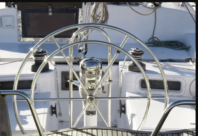 A boat deck showcasing a stainless steel wheel