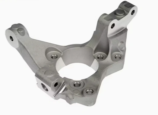 A closeup image of an intricate metal part with many holes of a steering knuckle