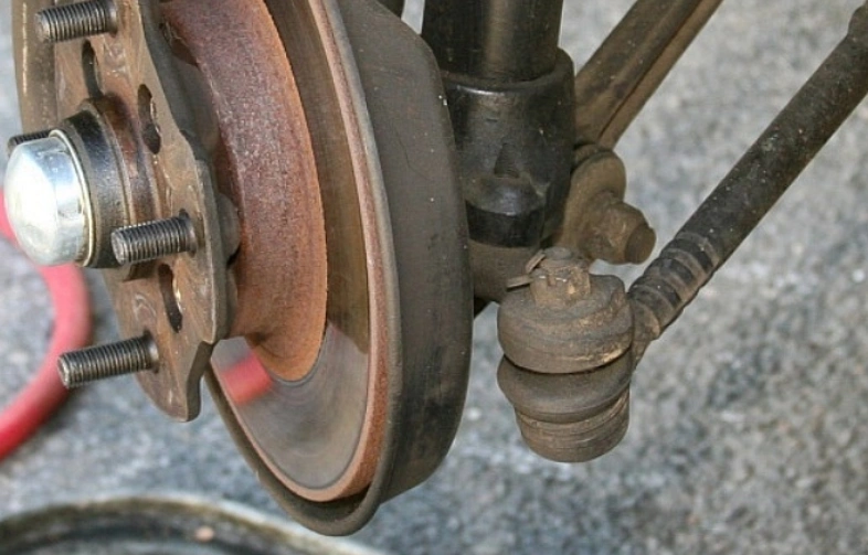 A closeup image of a tie rod end connecting to a steering knuckle