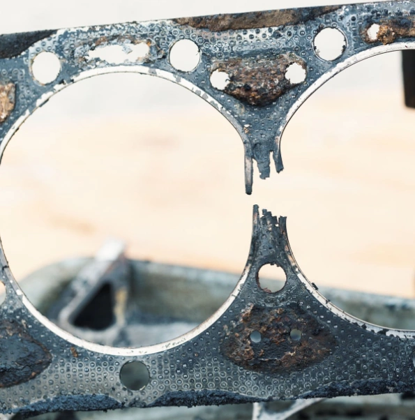 A closeup image of a section of a worn-out cylinder head gasket