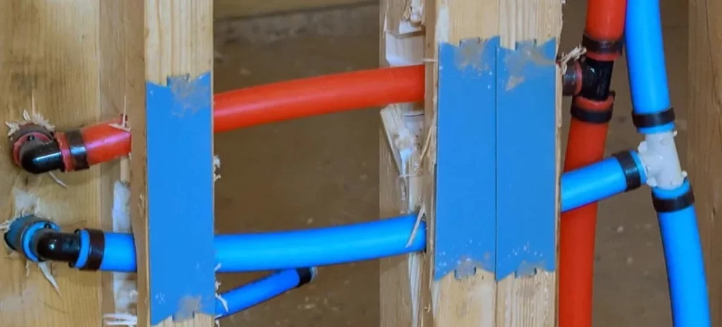 A set of blue and red joined plastic pipes curved due to thermal expansion 