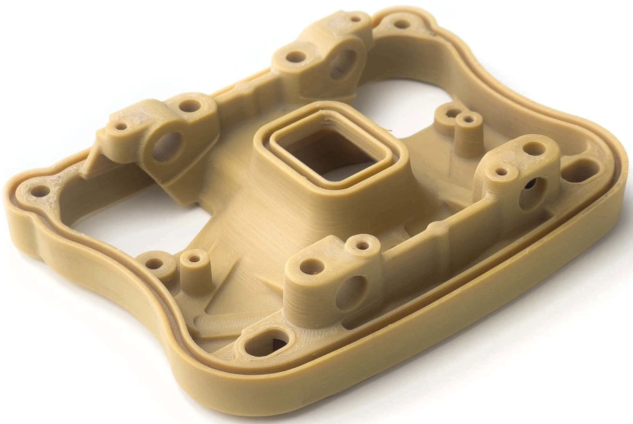 A 3D-printed PEEK component with complex geometric features and several mounting holes.