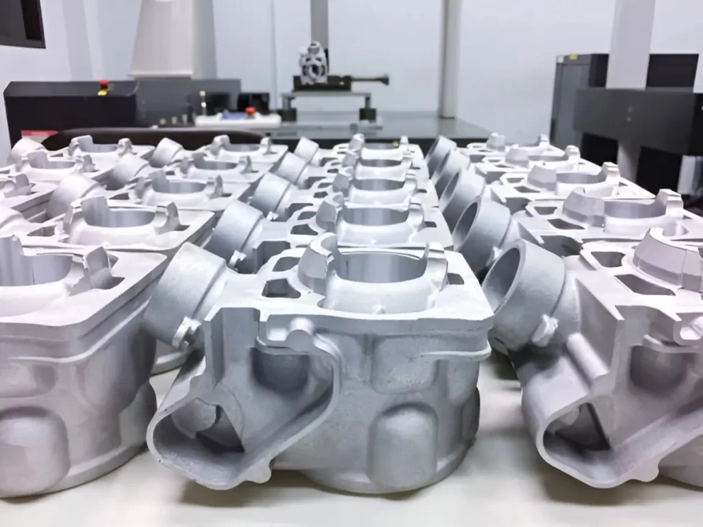 Bulk aluminum die-cast automotive components neatly arranged.