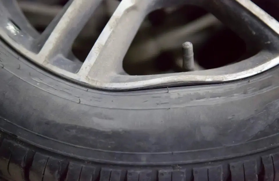 A closeup image of a bent alloy car wheel rim