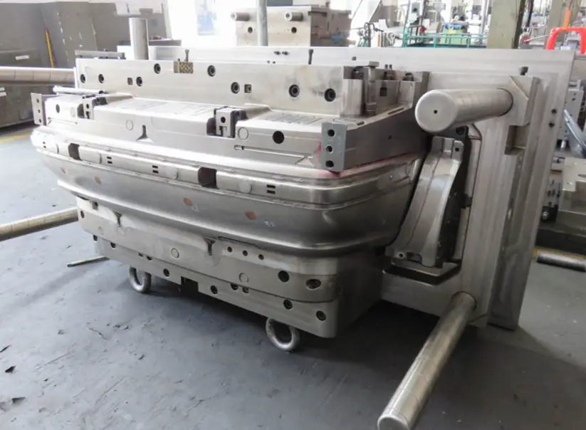 An image of a mold used for car bumper mold injection molding placed on a factory floor