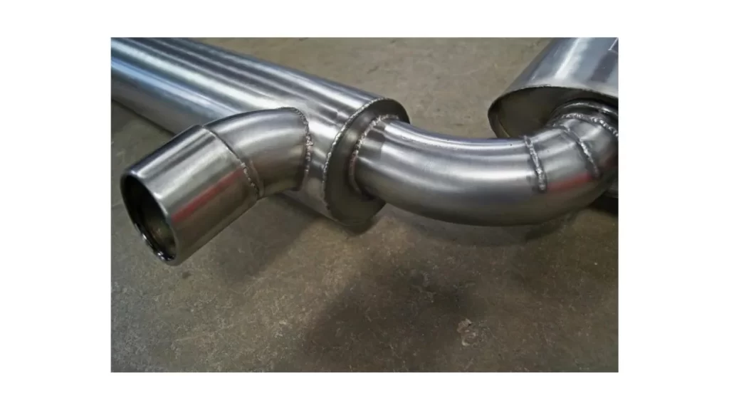 The image shows a custom exhaust system laid out neatly on the floor. 