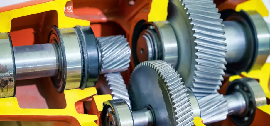 Gearbox of heavy machinery  with spiral gears in a red and yellow assembly