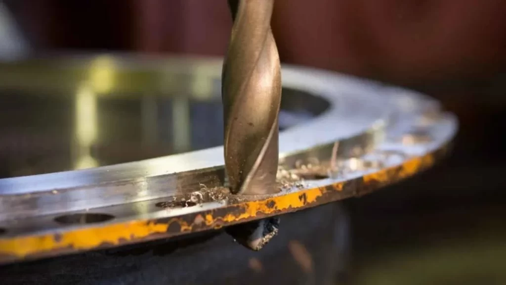 A close-up image of a hard drill bit, clearly showing its sharp edges and solid build. The image indicates its use for tough tasks like removing broken taps.