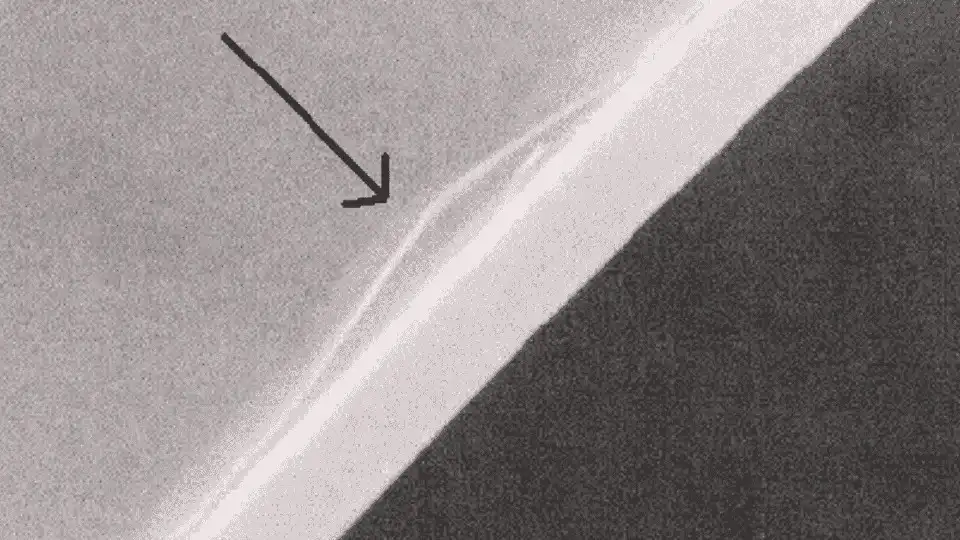 Illustration showing layer delamination in an injection molded part. The layers appear peeled off, indicating poor bonding between the material layers.