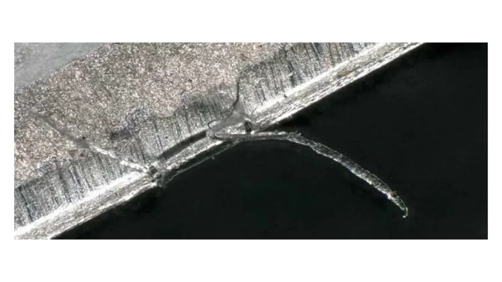 An image showing chipping on the surface of a metal workpiece. The defect is clearly visible as small pieces of material are broken off. 