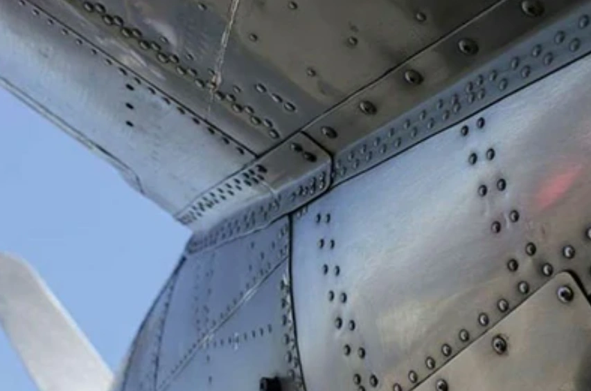 A closeup of riveted sheets of 7075 aluminum forming a section of a plane’s fuselage