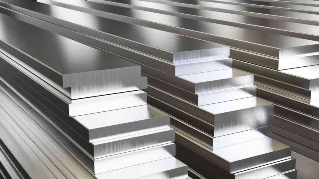 Close-up of neatly stacked, shiny silver aluminum alloy flat bars and sheets.