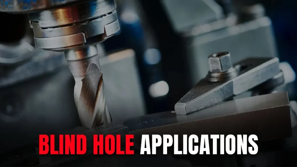 A close-up of a metal machining tool positioned above a metallic workpiece.