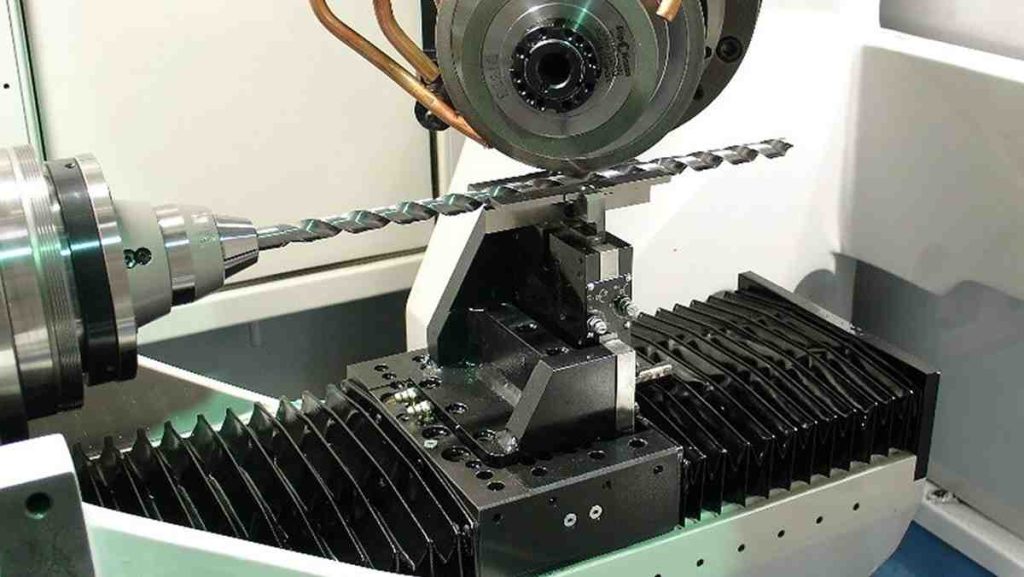Close-up of a precision drilling machine shaping a drill bit.