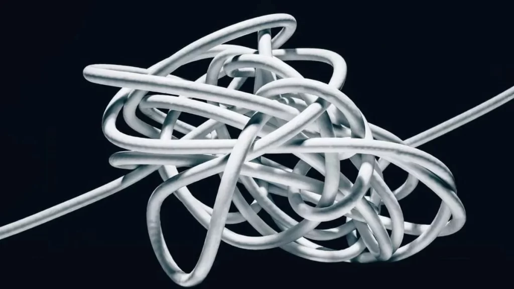 A tangled, shiny white or silver metallic wire on a dark background.