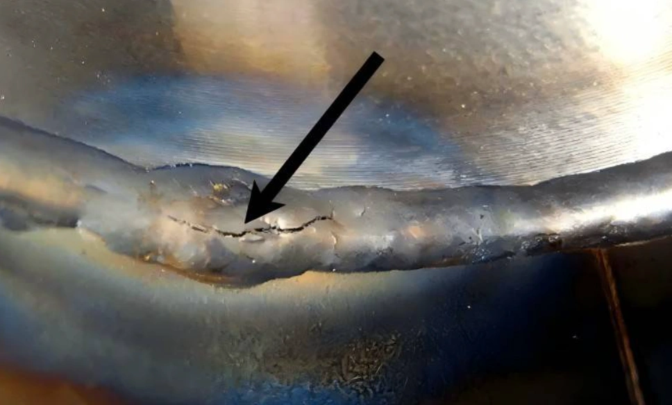 An aluminum weld with a hot cracking problem indicated by a black arrow