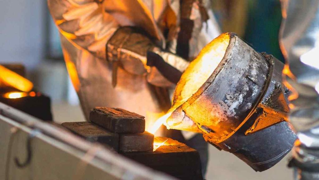 Pouring molten metal from a crucible into molds.
