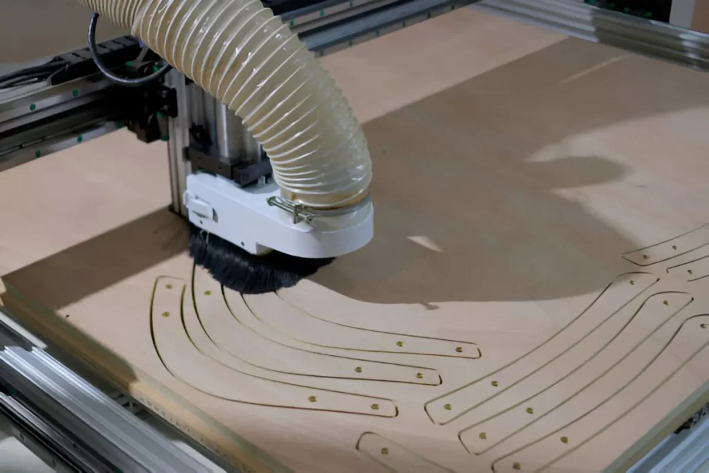 A robotic arm using a routing machine to create patterns on a wooden surface.