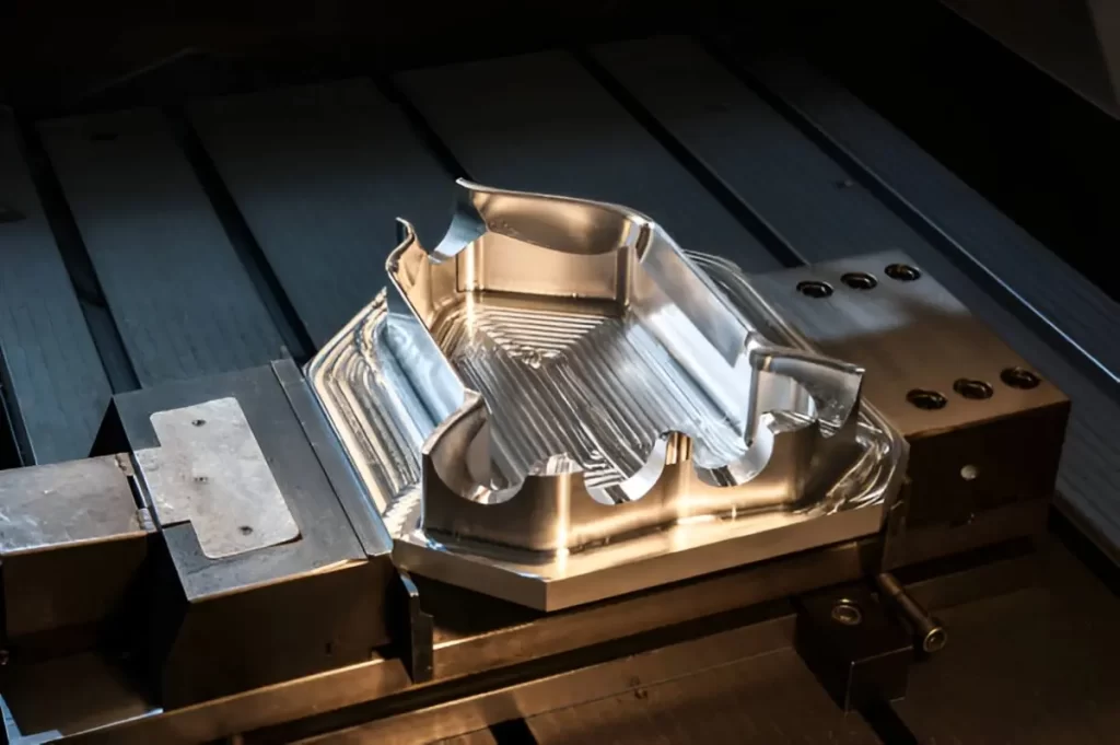 Depiction of a milled steel mold. It is showing detailed machining marks on the surface.