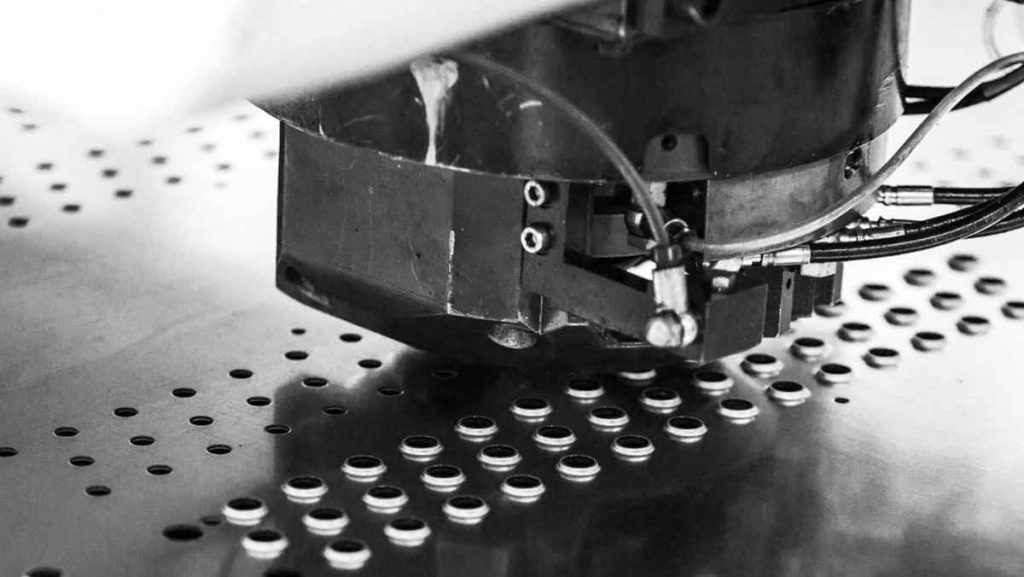 Close-up of a machine punching holes into a metal sheet
