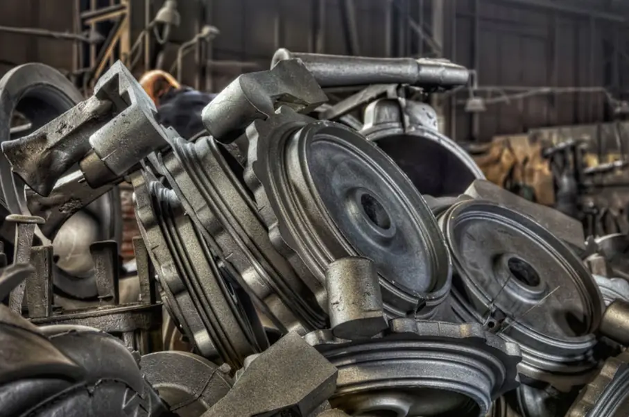 A closeup of a pile of gray disc-shaped  cast iron components  