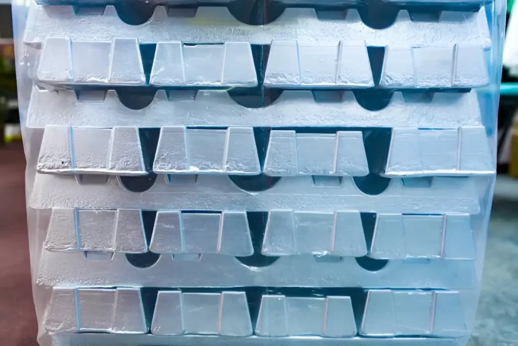 The image shows neatly stacked aluminum bar stock.