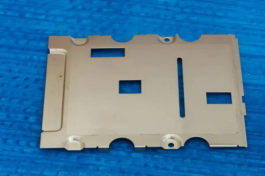 Aluminum stamped electronic part displayed on a table.
