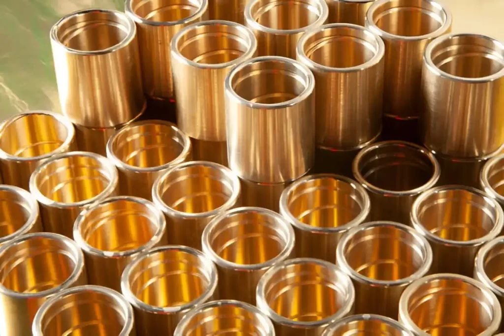 The image shows neatly arranged anodized brass machined parts.