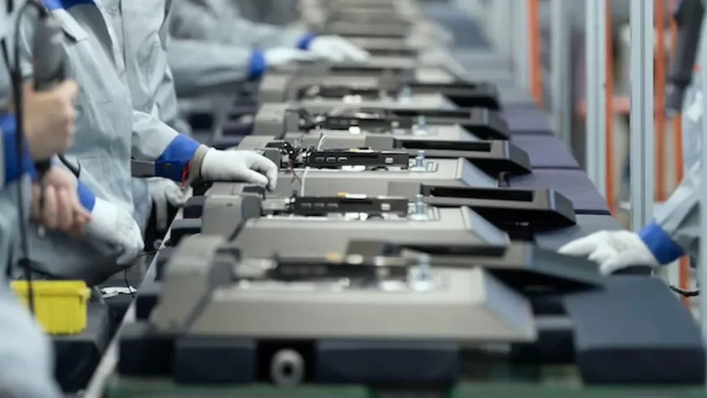 Workers assembling electronic components on a production line.