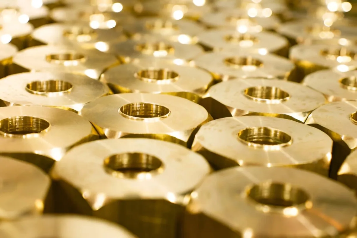 A gold-plated part with a bright gold finish reflecting the light