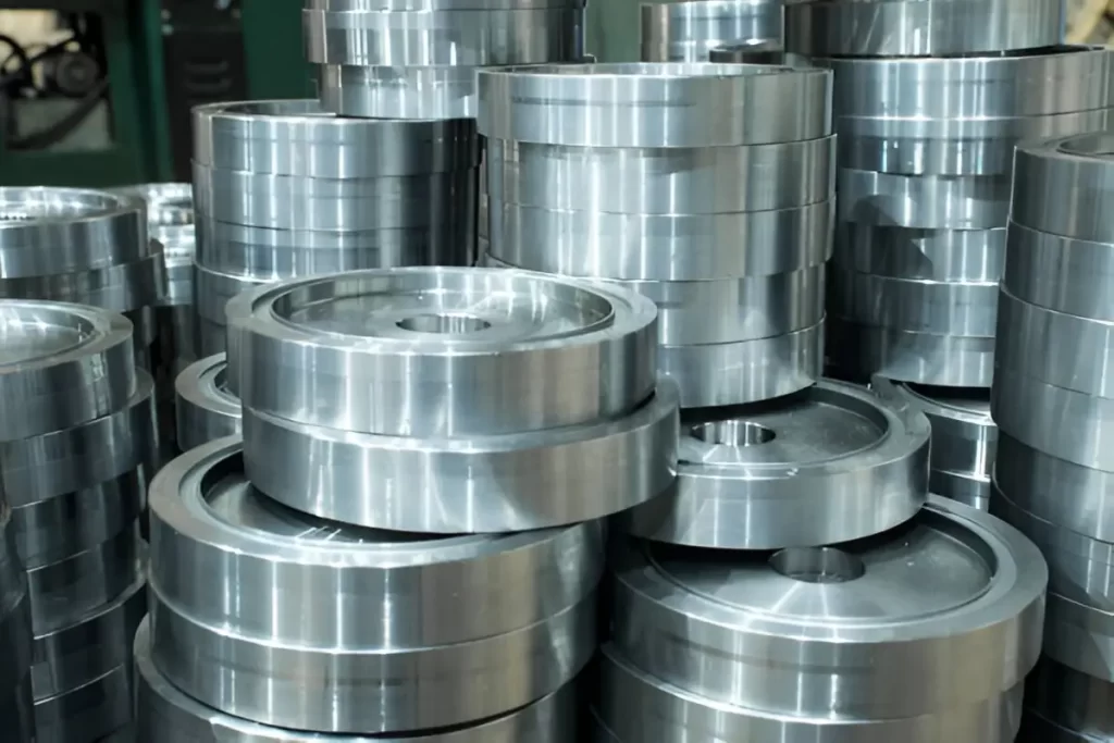 The image shows Kovar machined parts stacked in an industrial setting.