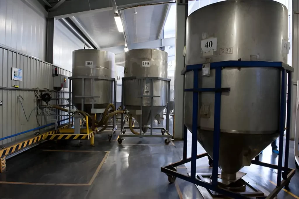 The image shows mild steel industrial tanks in an industrial setting.