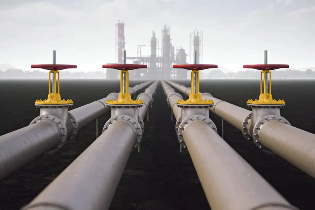 The image shows a close-up of steel pipelines used in the oil and gas industry.