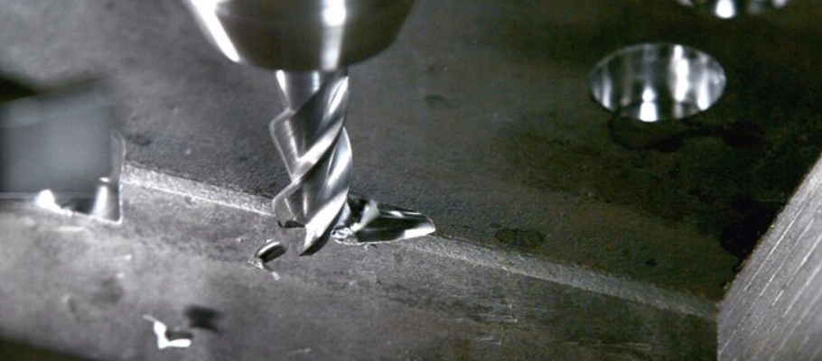A closeup image of a broken milling tool during deep cutting of a metal block