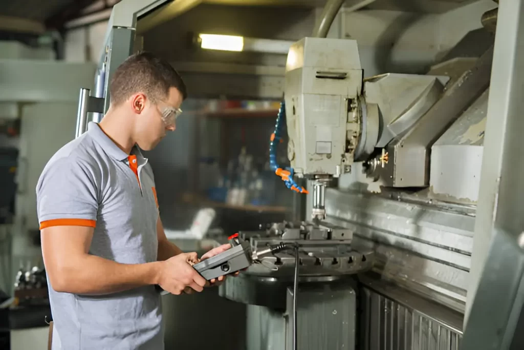 Metal worker operating a manual CNC machine.