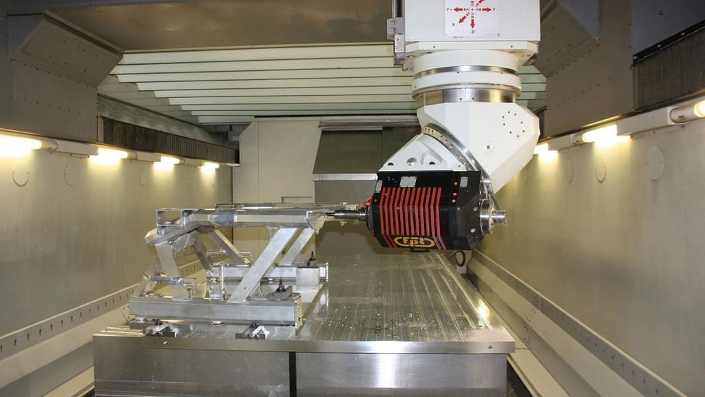 An image showing a CNC machine processing the car’s front frame.
