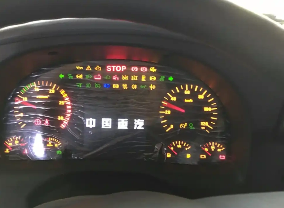 Car dashboard with illuminated gauges, multiple lights, and 