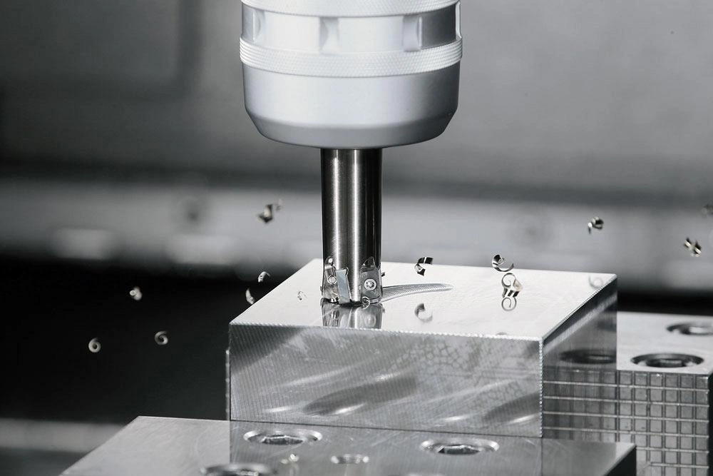 A close-up view of a CNC milling tool removing the material from the workpiece surface