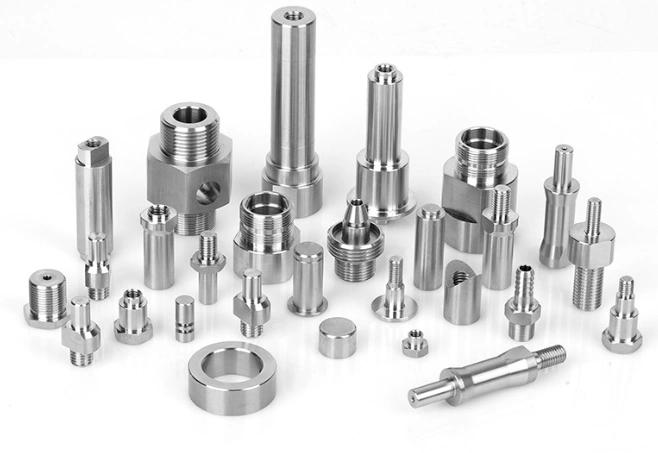 Collection of precision-machined stainless steel components, including threaded fittings, pins, connectors, and fasteners