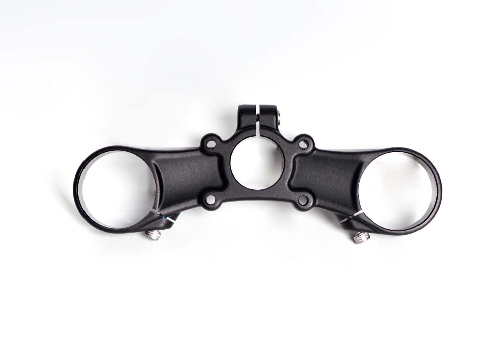 Complex forged aluminum motorcycle triple clamp showing intricate geometry 