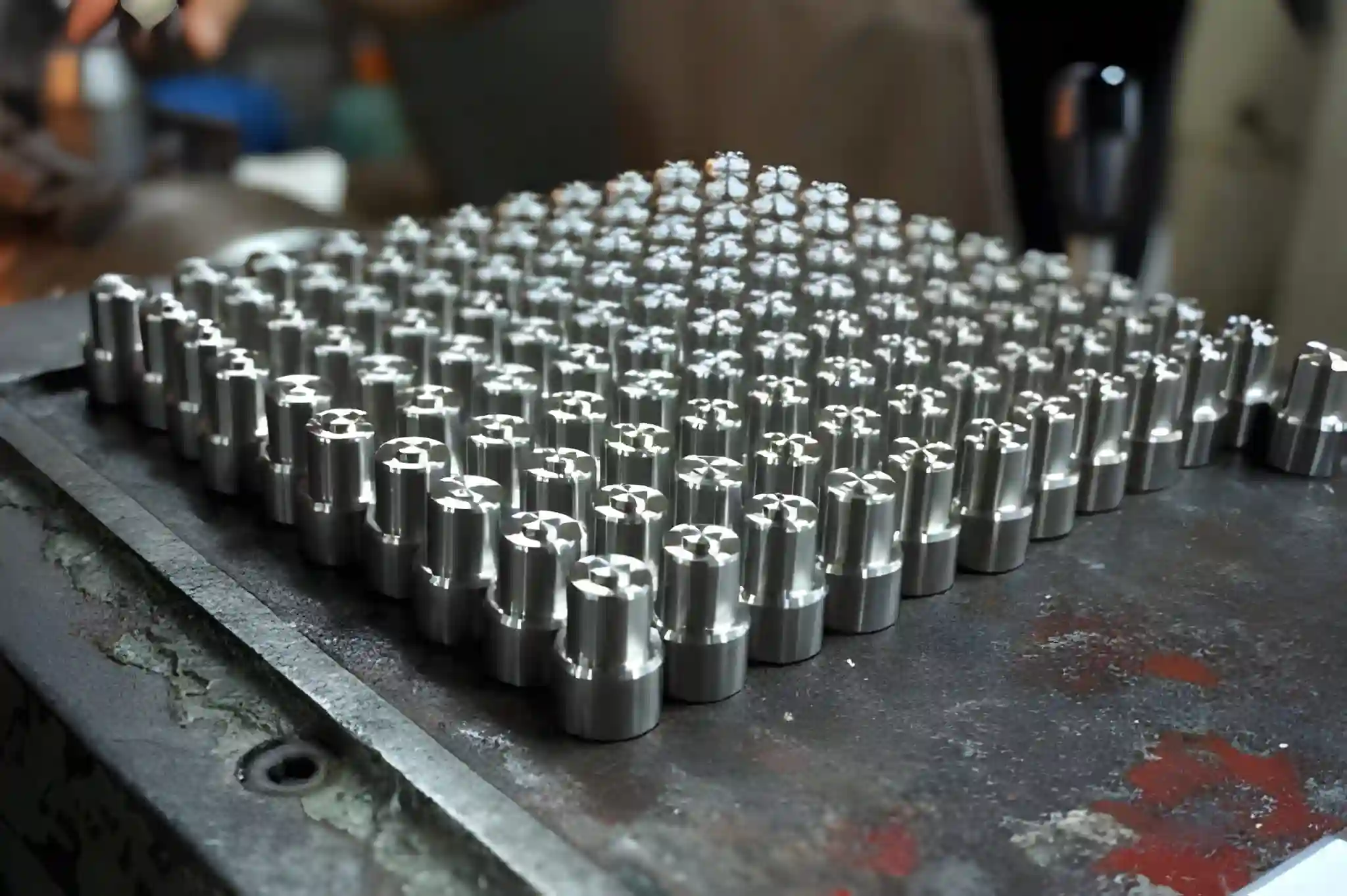 A group of CNC machined spare parts with smooth machined faces and fine tool marks, arranged on a bench after a fine machining pass