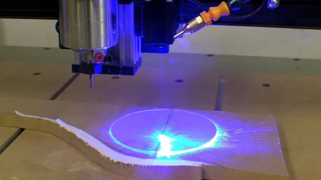 CNC laser cutting machine cutting a circular shape with blue laser light.