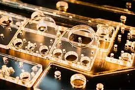 Precision-machined transparent acrylic components with drilled holes.